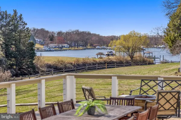 a view of a lake from a balcony with furniture