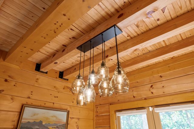 a view of a brick house with a yard plants and large tree