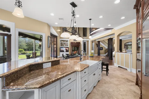a large kitchen with granite countertop a large island in the center and a large window