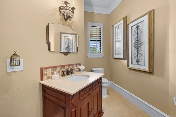 a bathroom with a granite countertop toilet sink and mirror