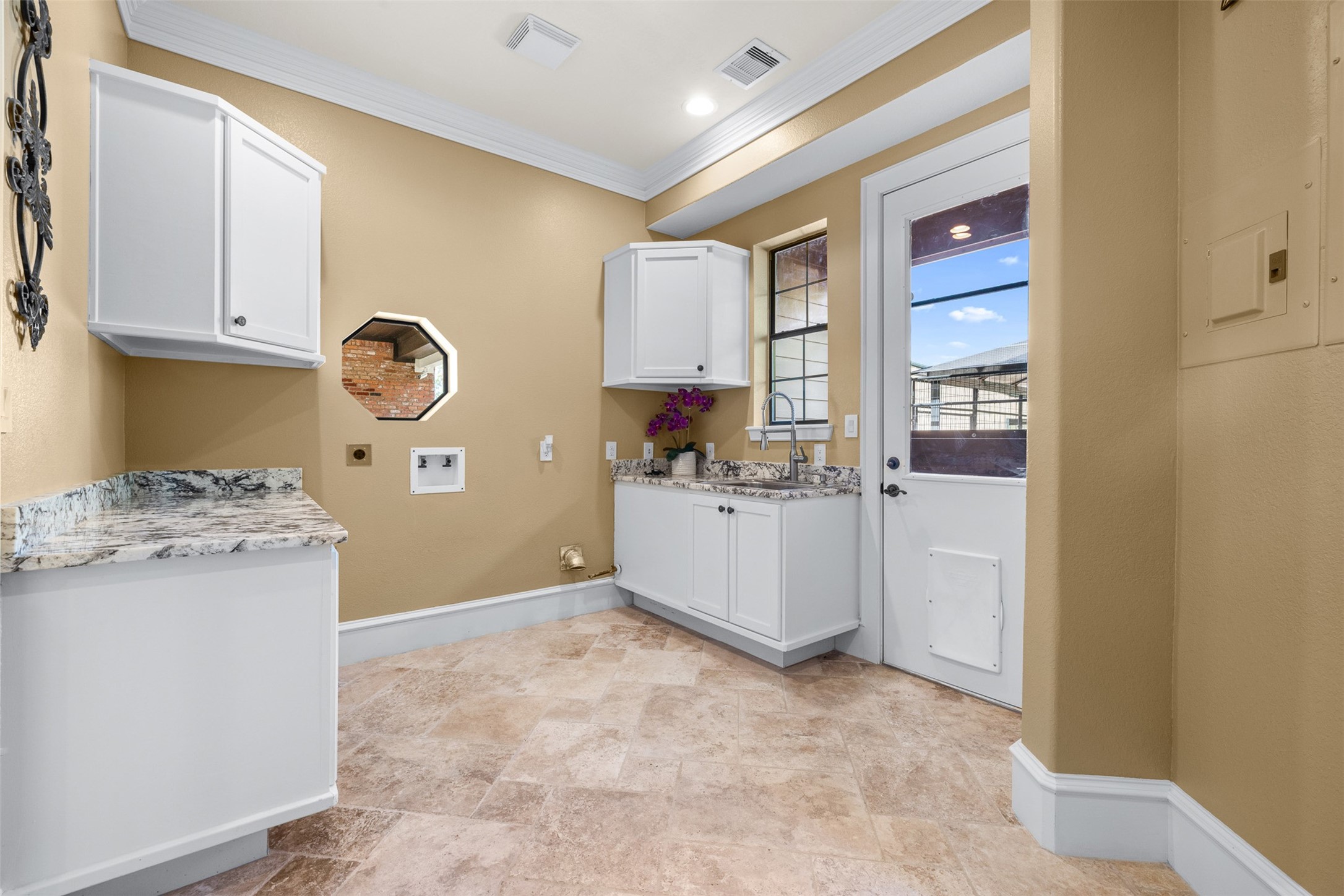 29500 Skymac Ranch Road Hempstead, TX 77445 - Photo 27 of 50 The laundry room is thoughtfully designed with built-in cabinetry for ample storage, along with a dedicated pet access door leading to a well-appointed pet room featuring a floor drain and direct access to a private outdoor area.