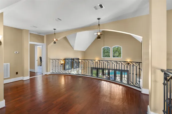 a living room with stainless steel appliances furniture a rug and a chandelier