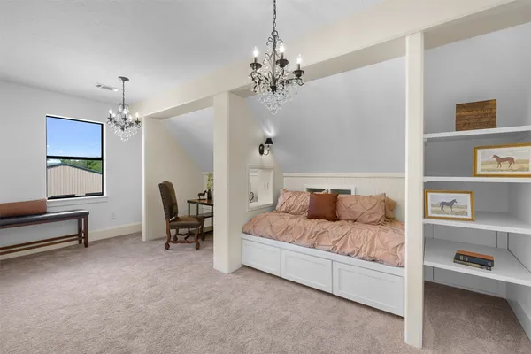 a spacious bedroom with a bed and a chandelier