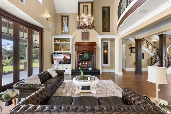 a living room with furniture a fireplace and a chandelier
