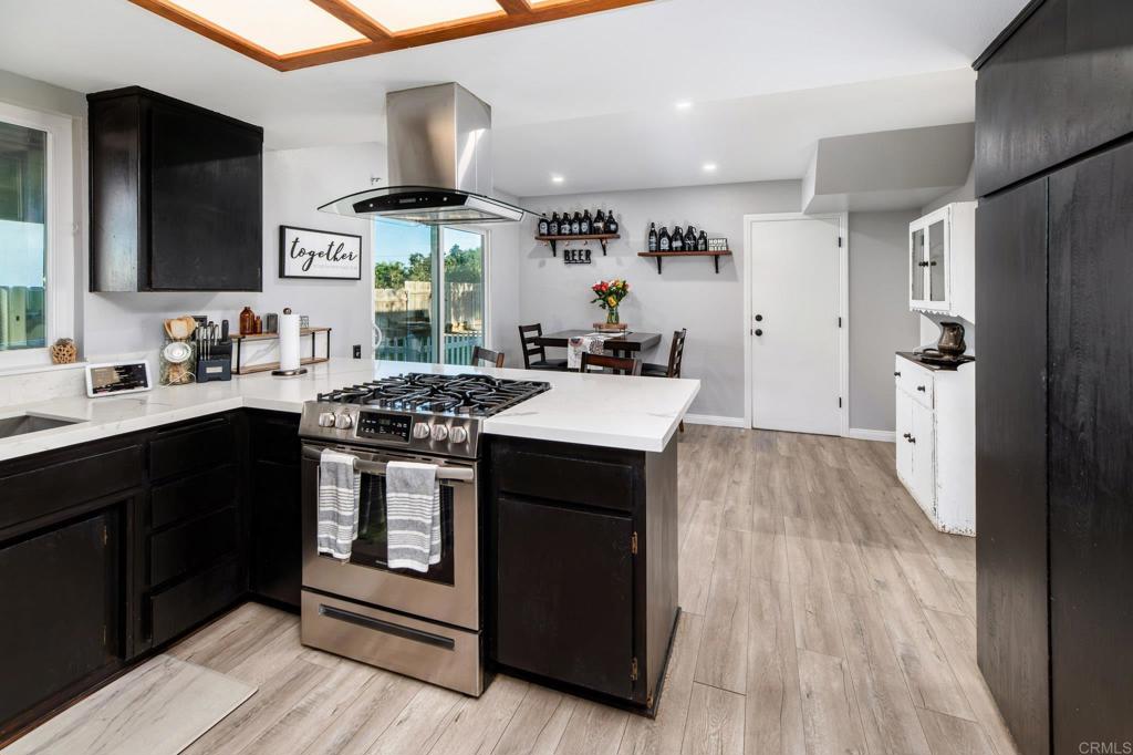 435 West Hawthorne Street Fallbrook, CA 92028 - Photo 14 of 42 a kitchen with stainless steel appliances a stove a sink dishwasher and a refrigerator with wooden floor