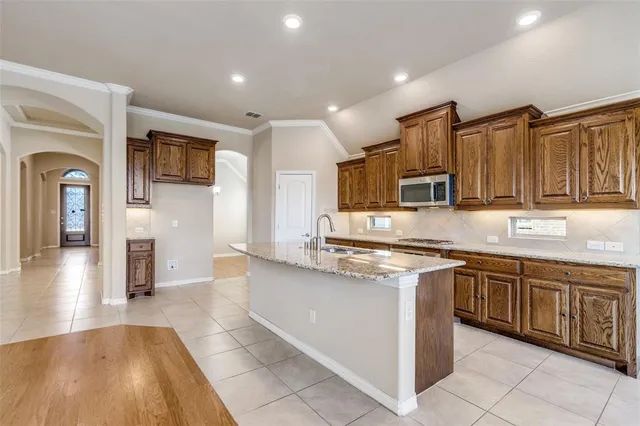 a large kitchen with stainless steel appliances granite countertop a stove and cabinets
