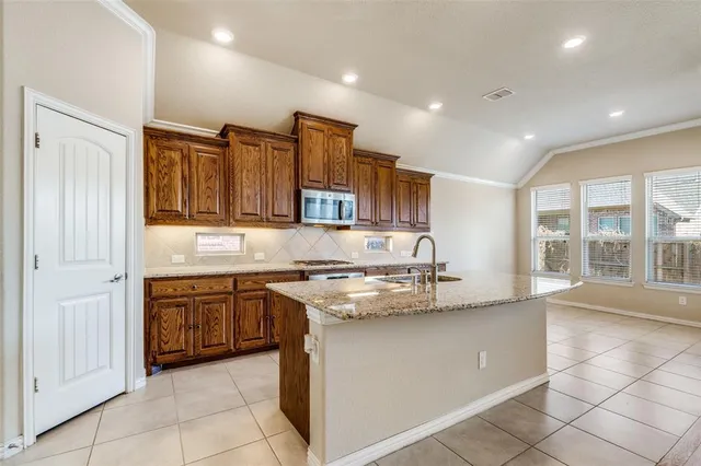 a kitchen with stainless steel appliances granite countertop a sink and a stove