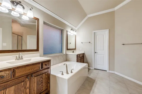 a bathroom with a tub a sink and mirror