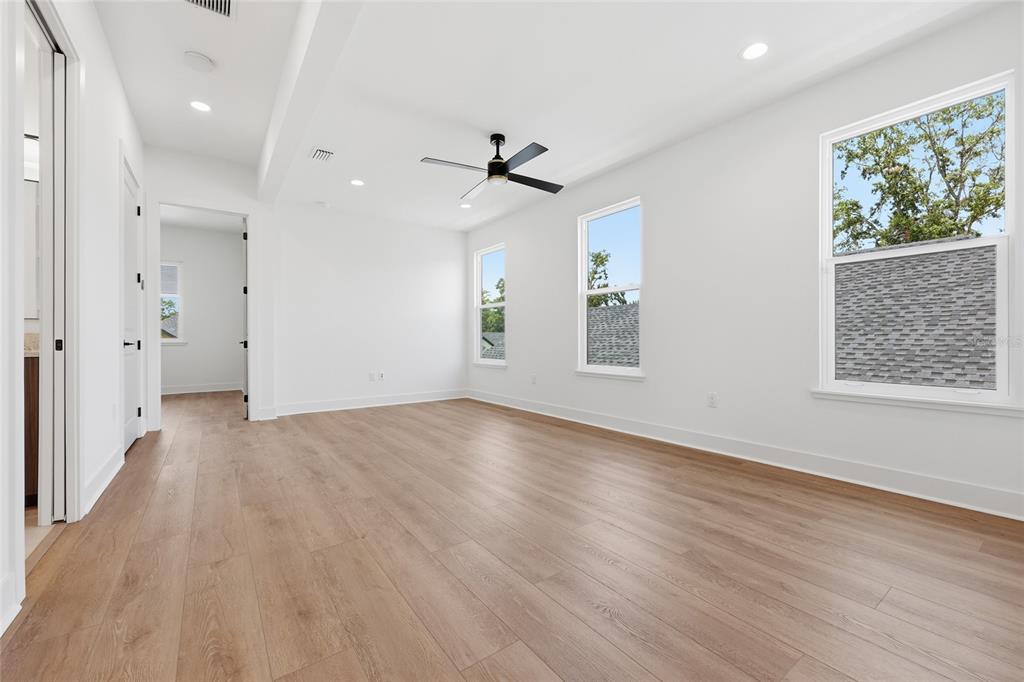 1063 Southwest 135th Way Newberry, FL 32669 - Photo 28 of 42 an empty room with wooden floor a ceiling fan and windows