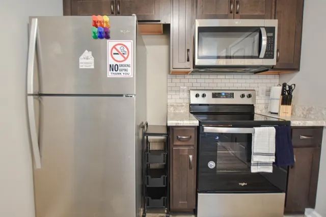 a kitchen with stainless steel appliances a refrigerator a stove and a microwave