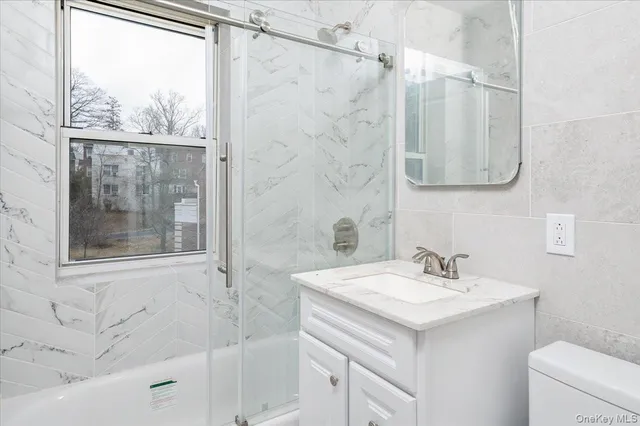 a bathroom with a sink and mirror with toilet