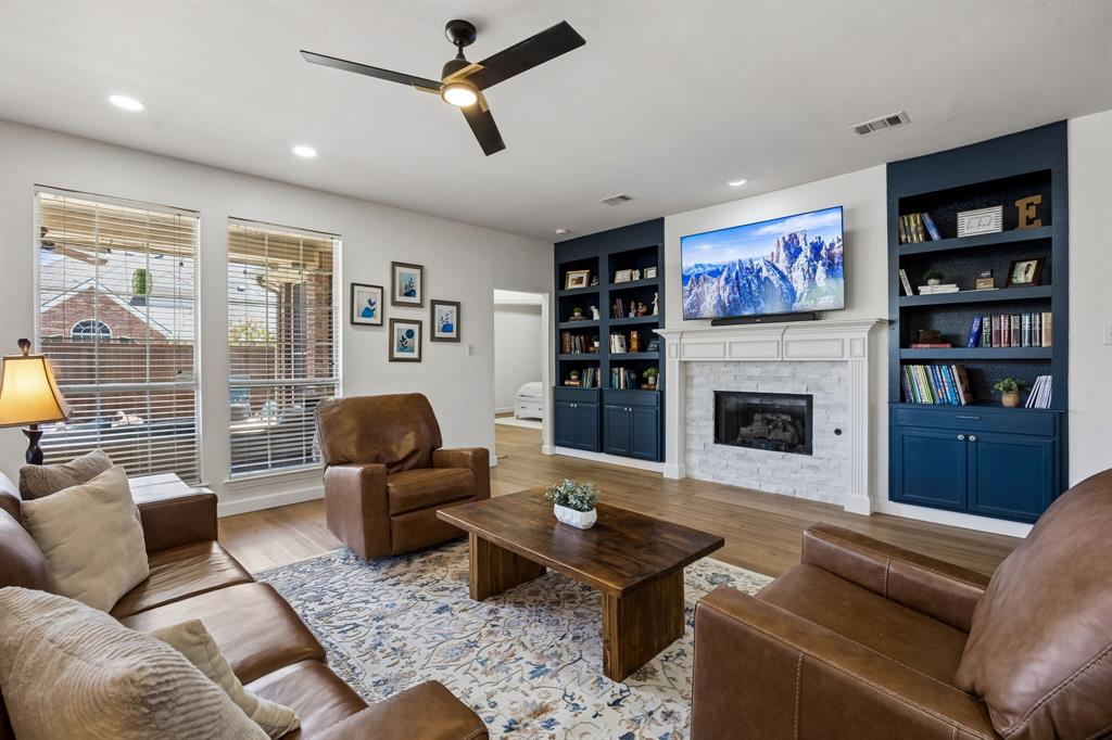 5315 Summit Knoll Trail Sachse, TX 75048 - Photo 3 of 40 a living room with furniture a fireplace and a flat screen tv