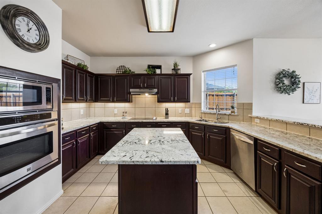 5315 Summit Knoll Trail Sachse, TX 75048 - Photo 9 of 40 a kitchen with stainless steel appliances granite countertop a stove top oven a sink and dishwasher