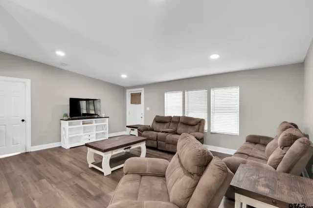 a living room with furniture and a wooden floor
