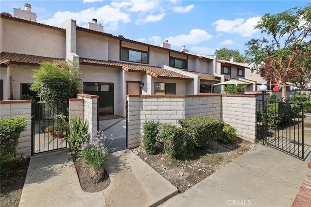 a view of a brick house with a flower garden