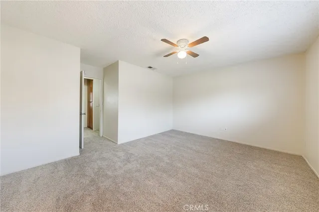 an empty room with windows and ceiling fan