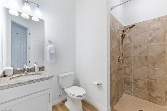 a bathroom with a granite countertop sink toilet and shower