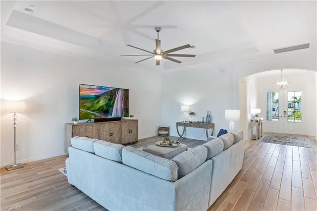 a living room with furniture a flat screen tv and a wooden floor