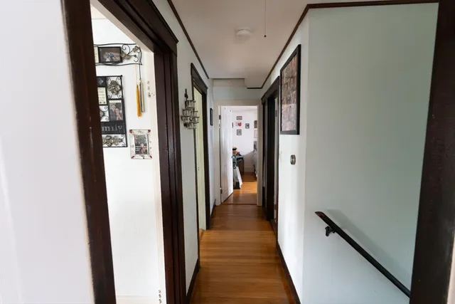 a view of a hallway with wooden floor and staircase