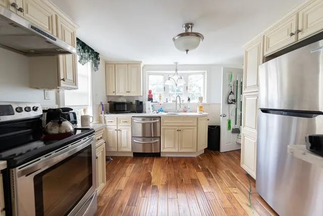 a kitchen with white cabinets sink and stainless steel appliances