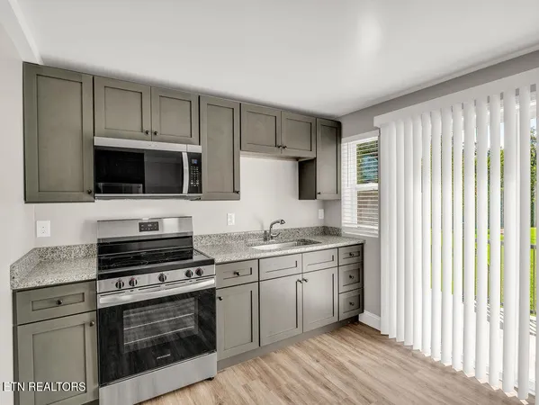a kitchen with stainless steel appliances a stove a sink and a microwave