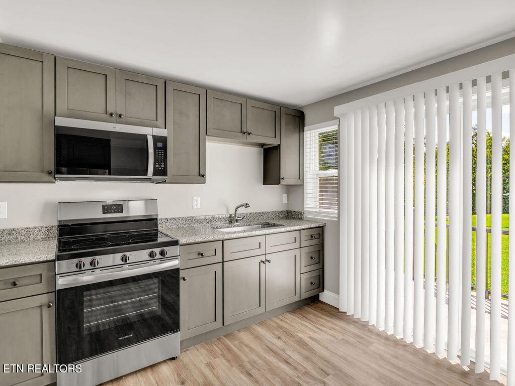 155 Tacoma Road Oak Ridge, TN 37830 - Photo 14 of 33 a kitchen with stainless steel appliances a stove sink microwave and cabinets
