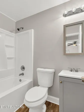a white toilet sitting next to a white bath tub sitting next to a white sink and vanity