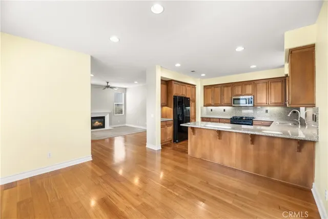a large kitchen with stainless steel appliances granite countertop a refrigerator and a sink