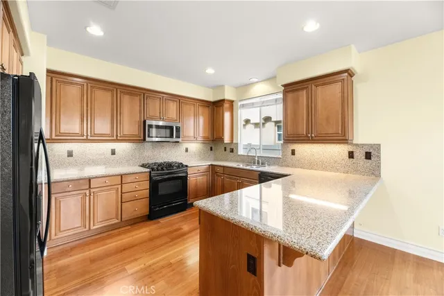 a kitchen with stainless steel appliances granite countertop a sink dishwasher stove and refrigerator