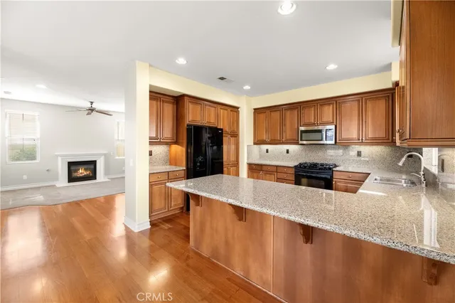 a large kitchen with granite countertop a stove a sink a refrigerator a stove top oven and a center island