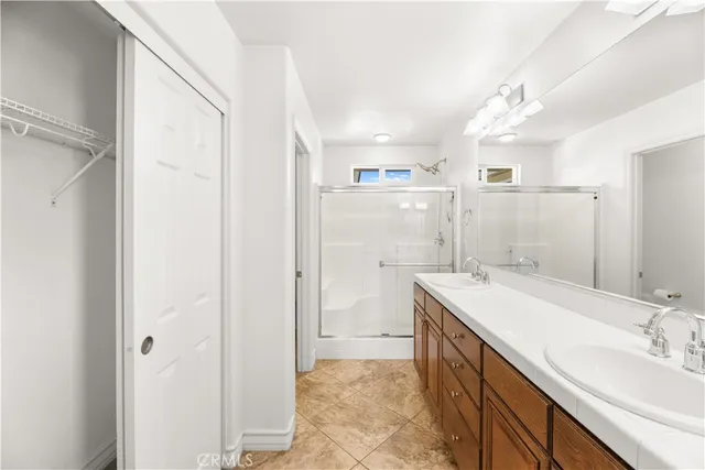 a bathroom with a double vanity sink mirror and shower