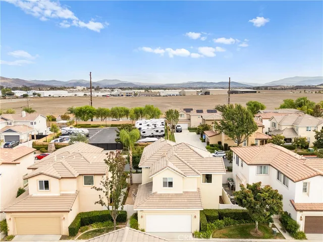 a view of a white house with a yard and potted plants