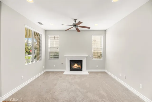 an empty room with windows and fireplace
