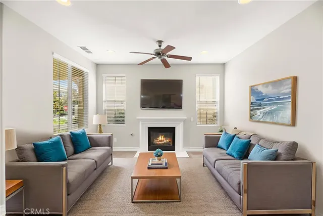a living room with furniture a flat screen tv and a fireplace