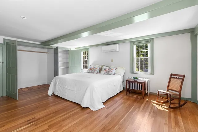 a spacious bedroom with a bed a table chair and a window