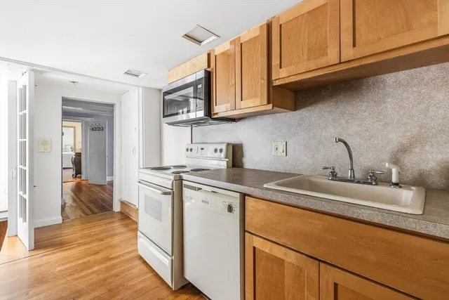 a kitchen with stainless steel appliances a stove microwave and sink