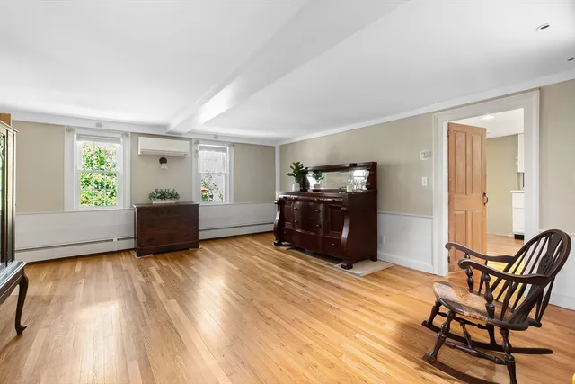 a view of a hallway with wooden floor and chair