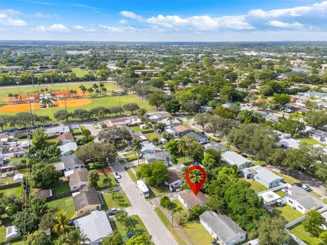 an aerial view of residential houses with outdoor space and ocean view