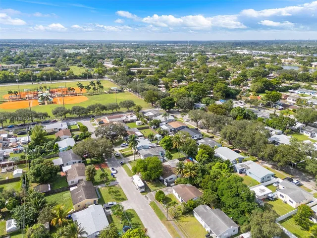 an aerial view of residential houses with outdoor space and ocean view