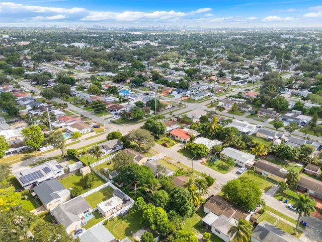 an aerial view of residential houses with outdoor space and trees