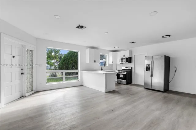 a view of a kitchen with a sink dishwasher and a refrigerator