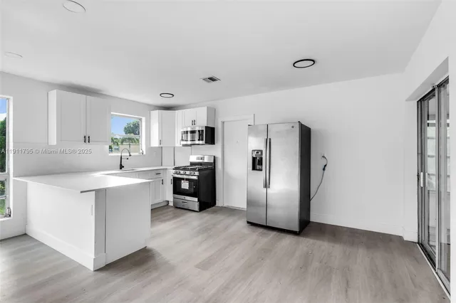 a kitchen with stainless steel appliances a refrigerator and a stove top oven