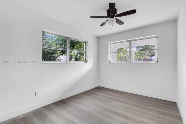 a view of room with hardwood floor and a ceiling fan