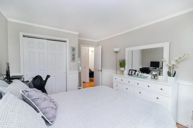 a bedroom with a bed and a large mirror