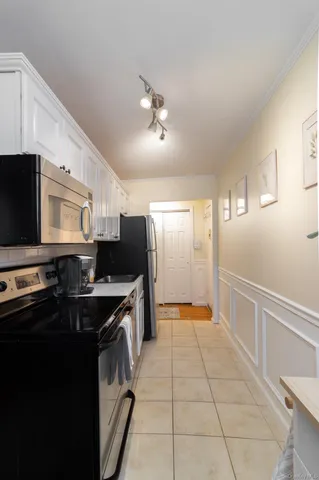 a kitchen with kitchen island granite countertop a sink appliances and cabinets