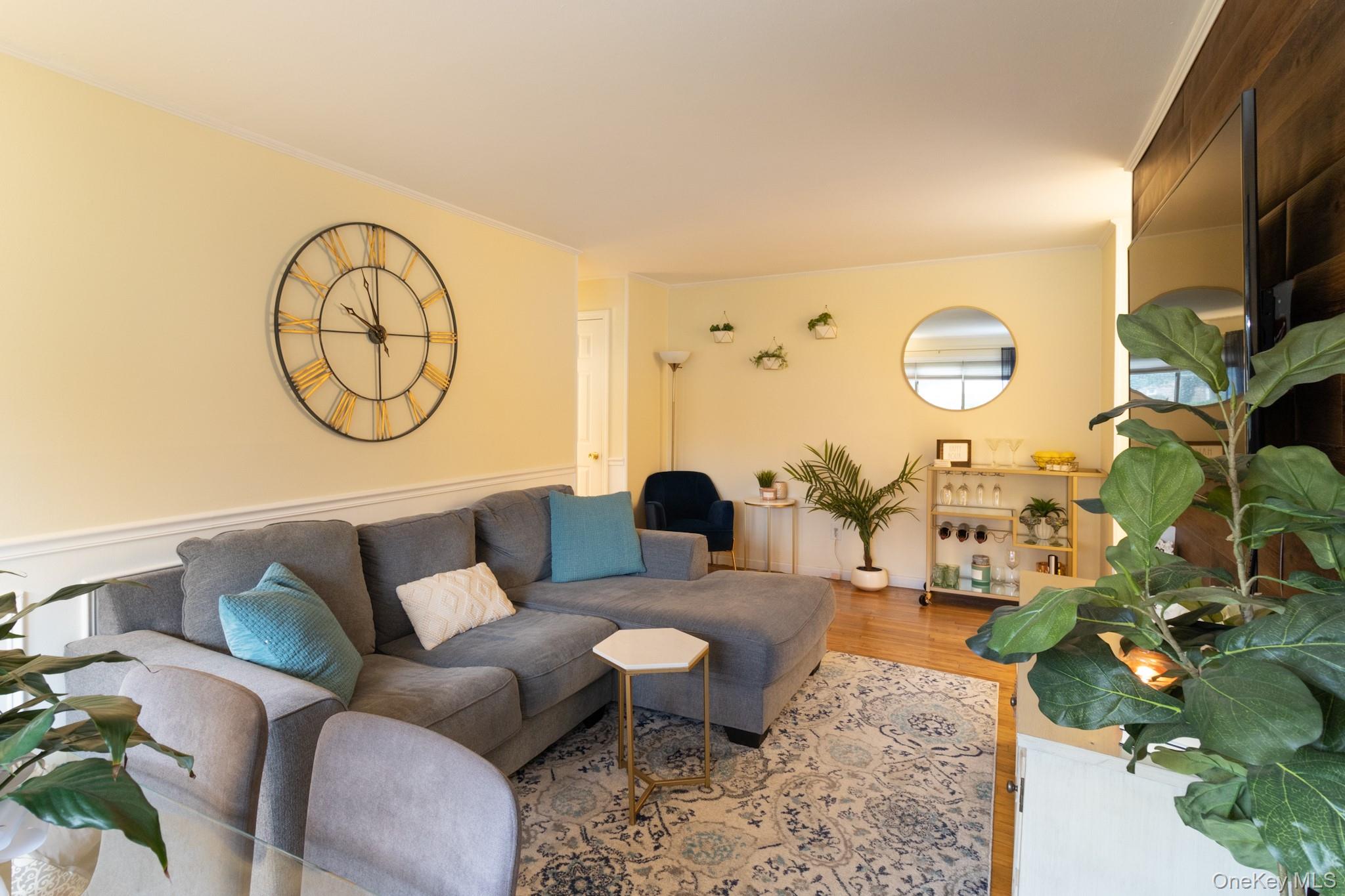 2449 Union Boulevard, Unit 36A Islip, NY 11751 - Photo 8 of 15 a living room with furniture a clock and a flat screen tv