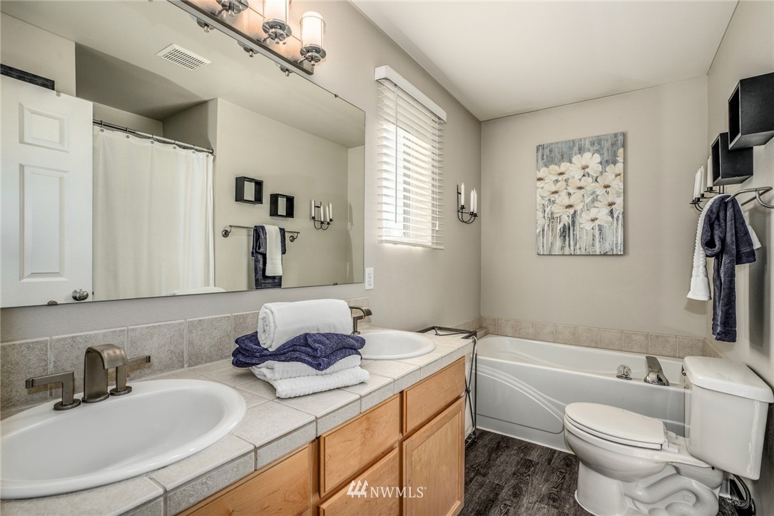 11417 Southeast 171st Street Renton, WA 98055 - Photo 16 of 27 a bathroom with a granite countertop sink mirror toilet and a bathtub