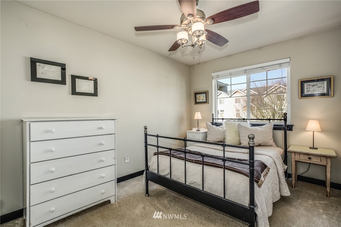 11417 Southeast 171st Street Renton, WA 98055 - Photo 19 of 27 a bedroom with a bed and a chandelier