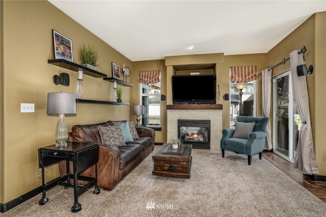 11417 Southeast 171st Street Renton, WA 98055 - Photo 6 of 27 a living room with furniture a flat screen tv and a fireplace