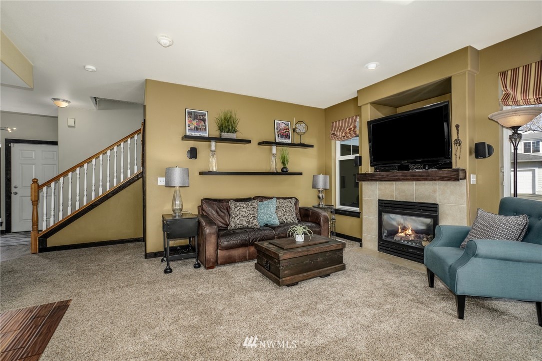 11417 Southeast 171st Street Renton, WA 98055 - Photo 8 of 27 a living room with furniture a flat screen tv and a fireplace